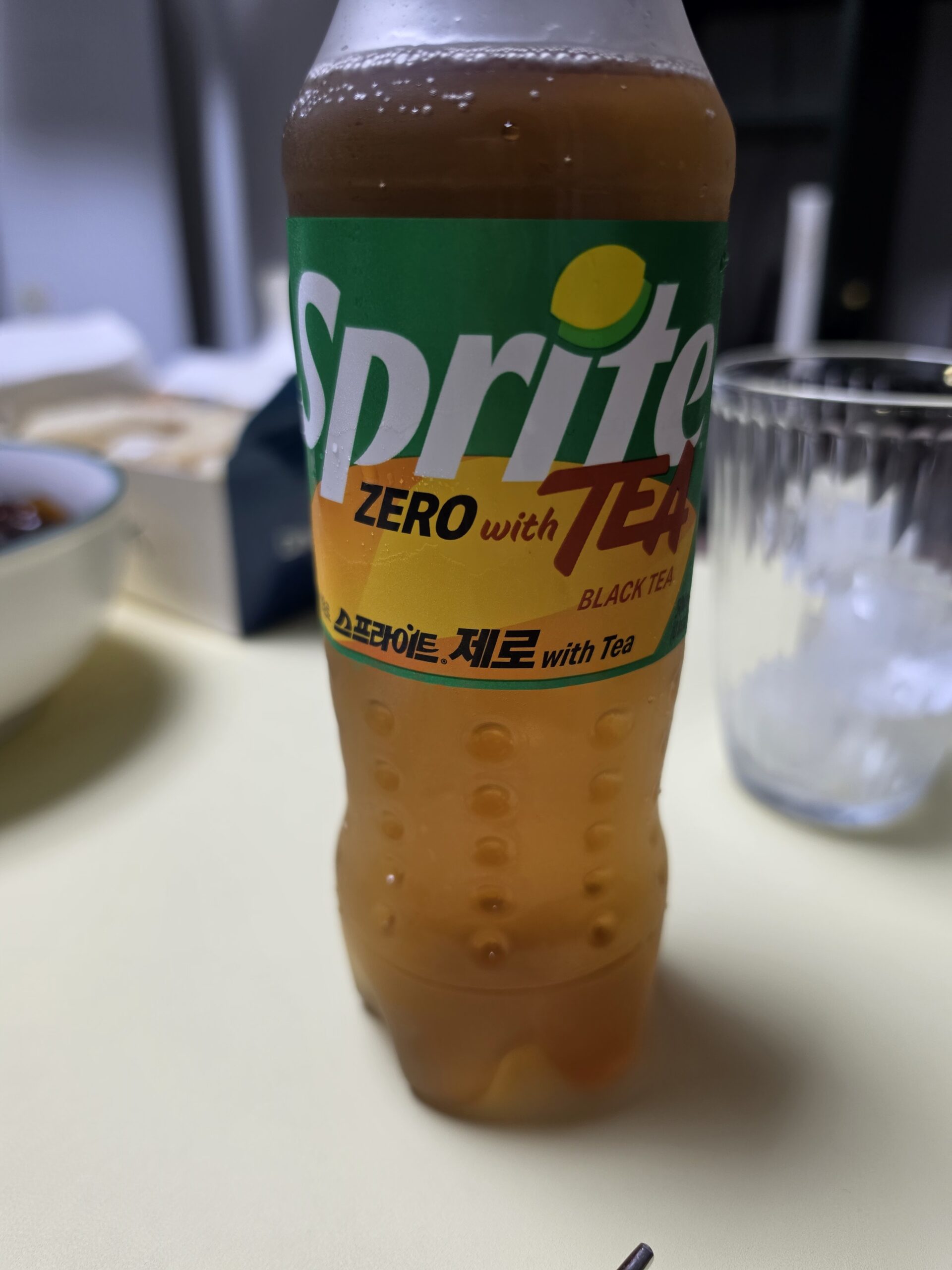 the Sprite Zero with Tea bottle, condensation dripping, contents a deep amber-orange