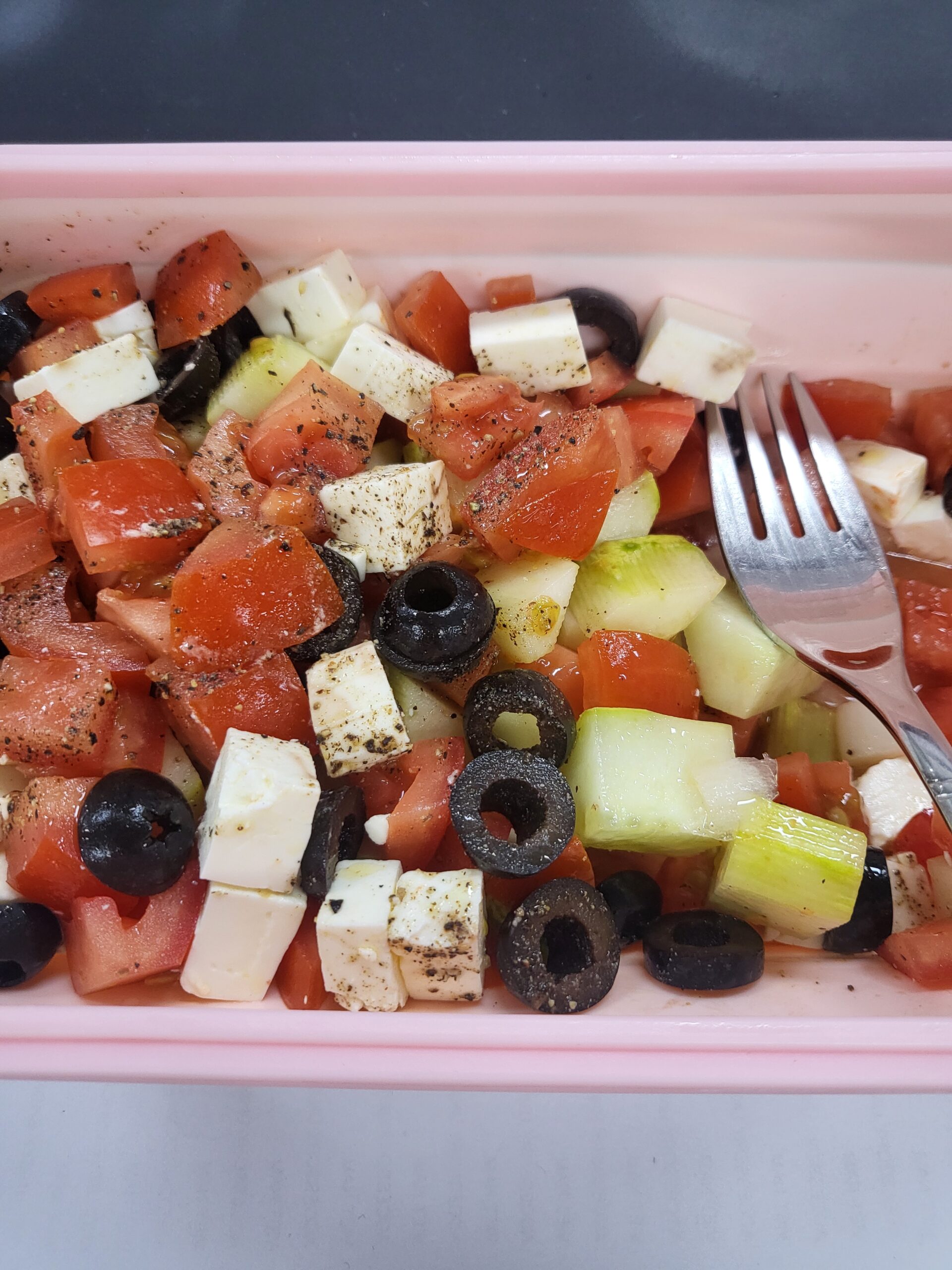 salad — feta, tomato, cucumber, olives — packed into the pink container
