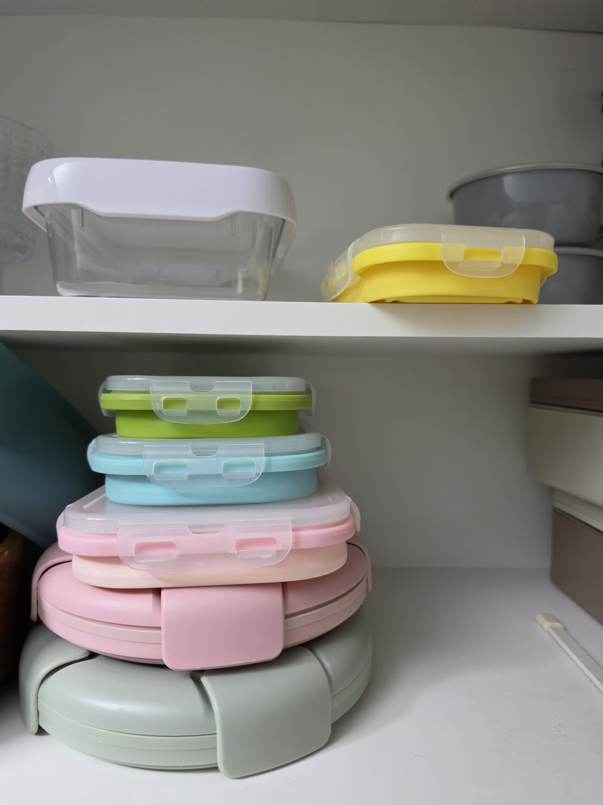 the full stack of folded containers — pink, mint, yellow, green, blue — collapsed down to almost nothing