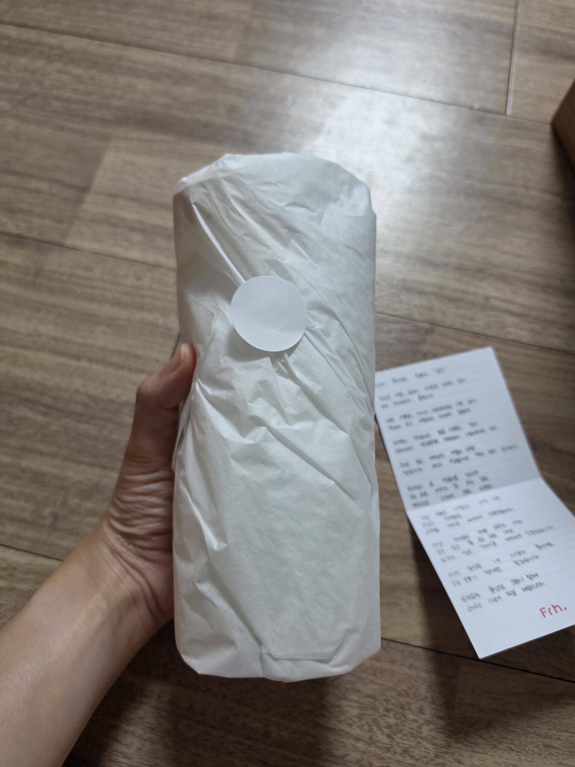 Unwrapping the ONEL Bottle from its tissue paper packaging with a handwritten note